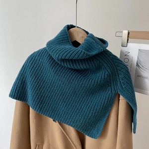 Close-up of a peacock blue turtleneck knit shawl over a camel coat for winter layering