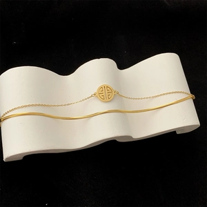 Double-layered vintage gold titanium steel bracelet with geometric pendant on a white stand