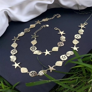 18K gold plated ocean shell starfish necklace and bracelet set on blue background
