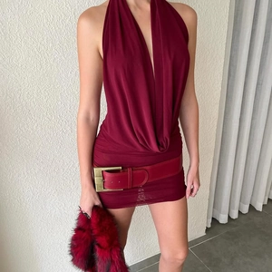 Detail of burgundy deep V-neck halter dress with wide leather belt and gold buckle