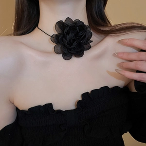 Detail of a large 3D black mesh flower choker necklace on a model for a chic look