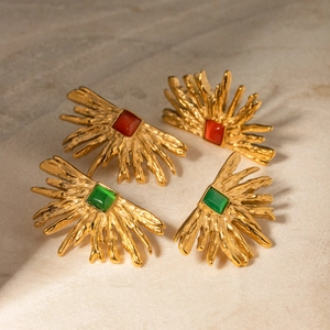 Detailed close-up of 18k gold-plated irregular sun earrings with red and green stones