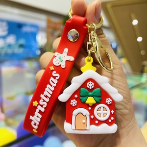 Close-up of a gingerbread house Christmas keychain with a red lanyard and cute charms