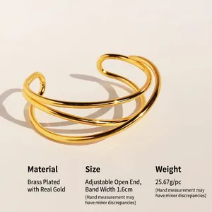 Bracciale rigido aperto con linee incrociate in metallo e finitura oro minimalista