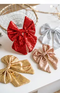 Close-up of glitter Christmas bows in red, silver, and gold for festive tree decoration