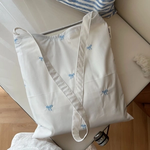 Sac bandoulière en toile de coton blanc avec broderie nœud bleu pour femmes