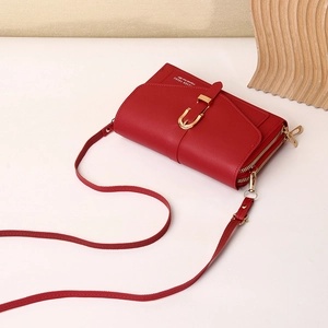 Detail of red PU leather crossbody phone bag with dual zippers and golden metal buckles