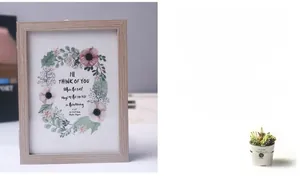 Detail of light wood 3D folding frame showing textured grain and floral interior art