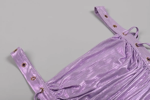Detail of purple metallic fabric featuring pleated texture and silver eyelets with lacing