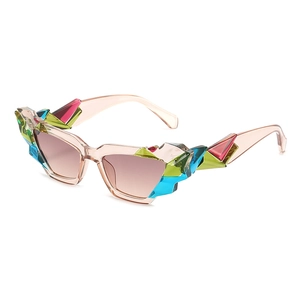 Fashionable cat eye sunglasses with colorful crystals and champagne frames on white backdrop