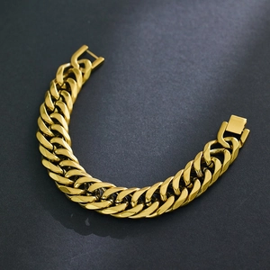Dettaglio ravvicinato del bracciale a catena cubana dorata con chiusura quadrata in metallo