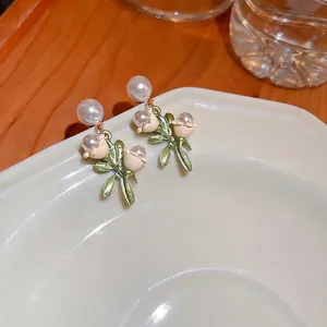 Boucles d'oreilles muguet élégantes avec fleurs en émail blanc et perles sur plateau blanc