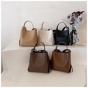 Detailed display of vintage bucket bags in five colors on a white minimalist pedestal
