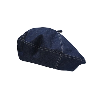 Dark blue denim beret with white contrast stitching on a clean white background
