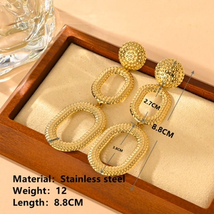 Detailed view of three-tier gold earrings with granular texture and size measurements