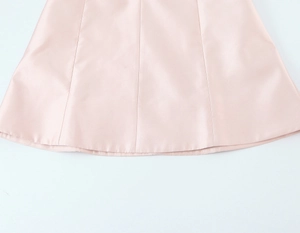 Gros plan de l'ourlet de la robe en satin rose montrant les coutures et la texture