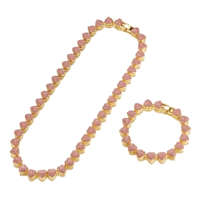 Detail of 10mm gold Cuban chain necklace and bracelet set with pink heart rhinestones