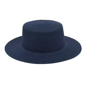 Detail of navy blue straw flat-top sun hat featuring fine woven texture and flat brim