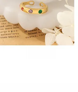 Close-up of gold plated ring with colorful zircon stones on a white cloud stand