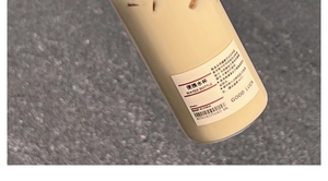 Detail showing cream portable plastic water bottle with Good Luck text and info label