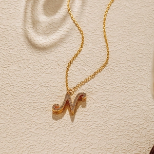 Macro shot of 18K gold plated letter N pendant necklace encrusted with clear zircon stones