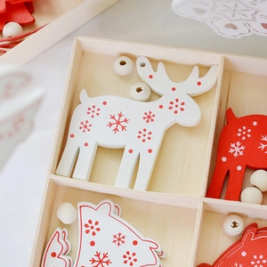 Nordic wooden Christmas tree ornaments set with red and white snowflake patterns in a box