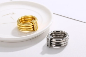 Detailed close-up of 18k gold and silver multi-layer rings with rectangular zircon stones