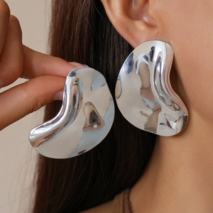 Abstract silver wavy geometric metal earrings with high gloss finish on a female model