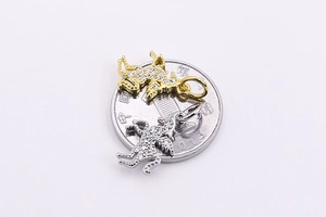 Dettaglio di ciondoli a forma di unicorno argento e oro su moneta per mostrare le dimensioni