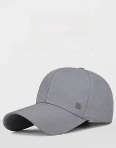 Detail of grey baseball cap showing textured fabric and silver metallic R logo emblem