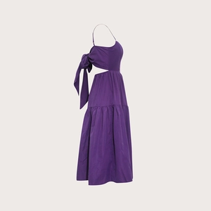 Détail d'une robe bohème violet foncé avec découpe latérale et grand nœud décoratif