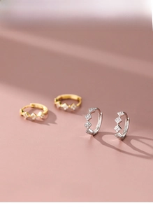 Macro shot of S925 silver geometric diamond earrings in silver and gold finishes