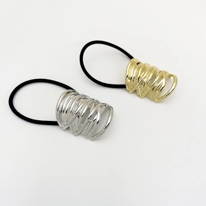 Macro detail of high-elasticity hair ties with hollow gold and silver metal spiral accents