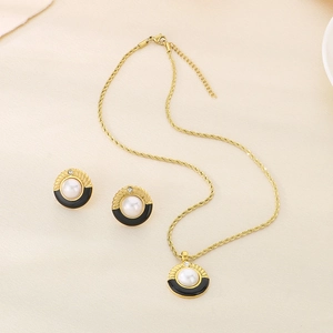 Dettaglio di parure gioielli vintage con smalto nero, conchiglia e perle