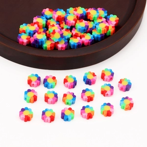 Colorful polymer clay flower beads for DIY jewelry making displayed on a wooden tray