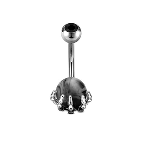 Macro shot of punk style belly ring featuring silver skull claw holding a marble bead