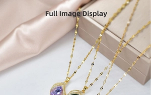 Close-up of golden teardrop pendant necklace with purple and green stones on silk