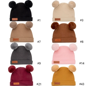Winter knit baby beanie with double faux fur pom-poms shown in multiple colors