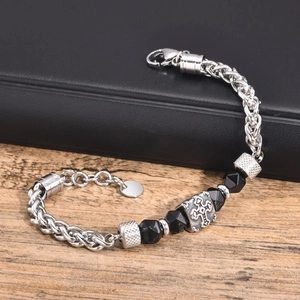 Macro view of vintage stainless steel men's bracelet with black beads and cross motif