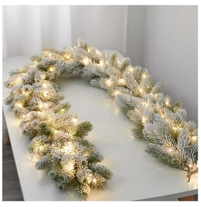 Dettaglio della ghirlanda natalizia floccata con luci LED bianche calde per decori