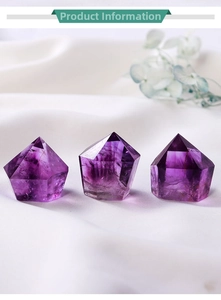 Detailed view of three natural purple amethyst hexagonal pillars on white silk fabric