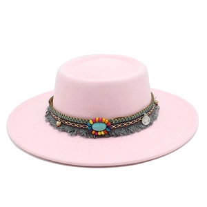 Détail du chapeau en feutre rose avec ruban tressé bohème, turquoise et glands décoratifs