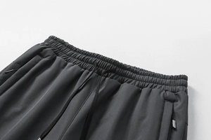 Detail der dunkelgrauen Jogginghose mit elastischem Kordelzug und Reißverschlusstaschen