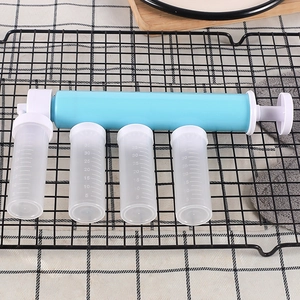 Manual cake airbrush set with blue pump and four clear nozzles on a black cooling rack