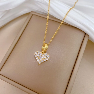 Nahaufnahme der herzförmigen Goldkette mit funkelnden Kristallen in einer Schmuckschatulle
