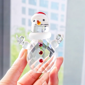 Detail of faceted crystal snowman figurine with red hat and scarf for Christmas decor