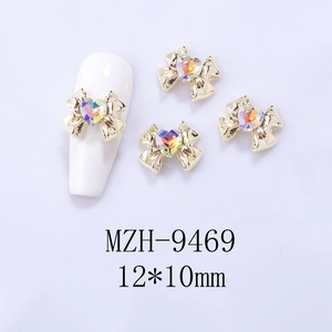 Macro shot of 12x10mm gold bow nail charms with AB heart rhinestones and model display