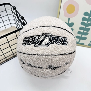 Detail of white sherpa basketball pillow with black Soulful and Dream Bigger embroidery