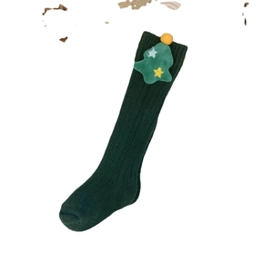 Dark green knitted Christmas socks for kids featuring plush holiday tree decorations