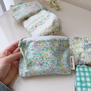 Détail de mini porte-monnaie en coton à fleurs et carreaux avec cordon de serrage